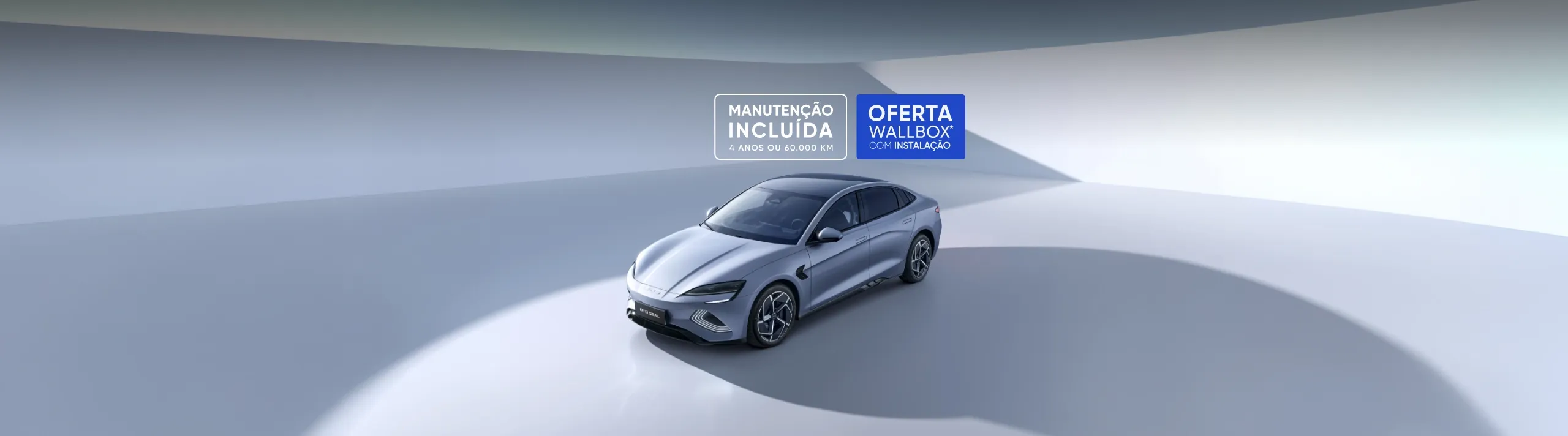 Sedan elétrico BYD Seal prateado em estúdio. Texto flutuante no topo anuncia ofertas de manutenção incluída (4 anos) e Wallbox gratuito com instalação.