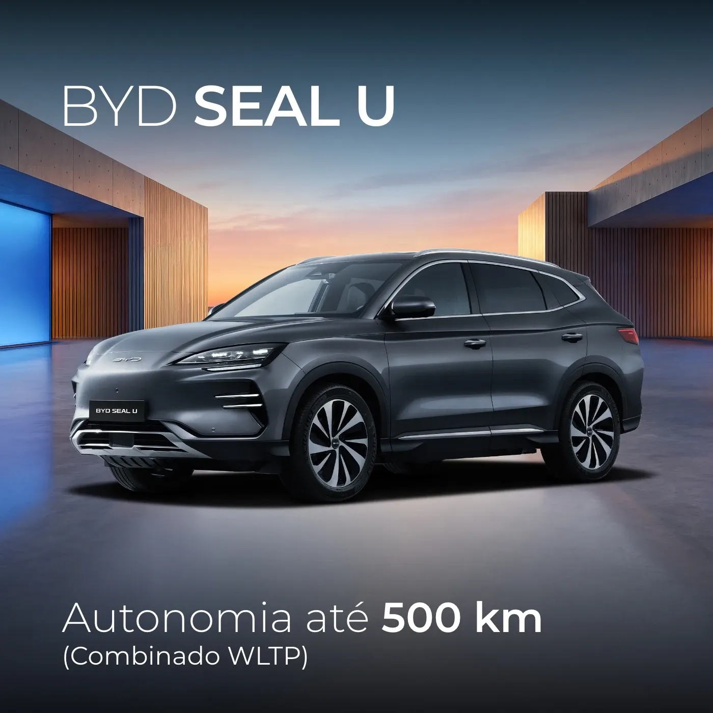 SUV elétrico BYD Seal U em cinzento escuro, visto de frente em ângulo de três quartos num cenário arquitetónico moderno.