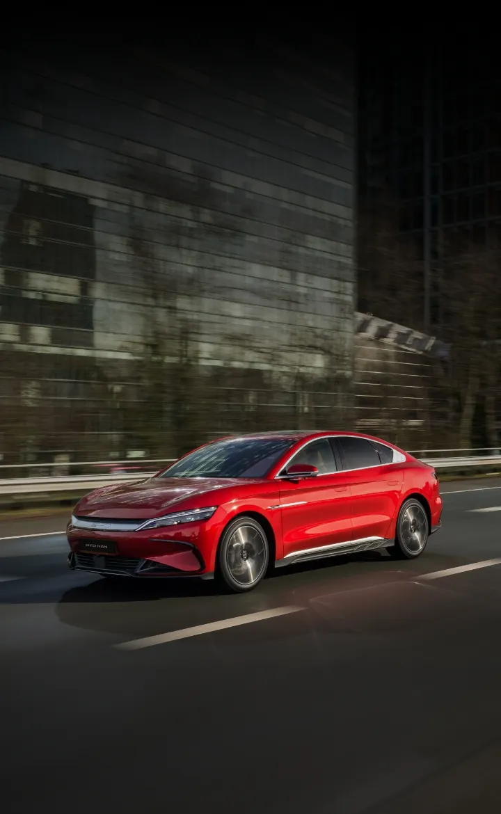 BYD HAN percorre as ruas de uma cidade com edifícios espelhados