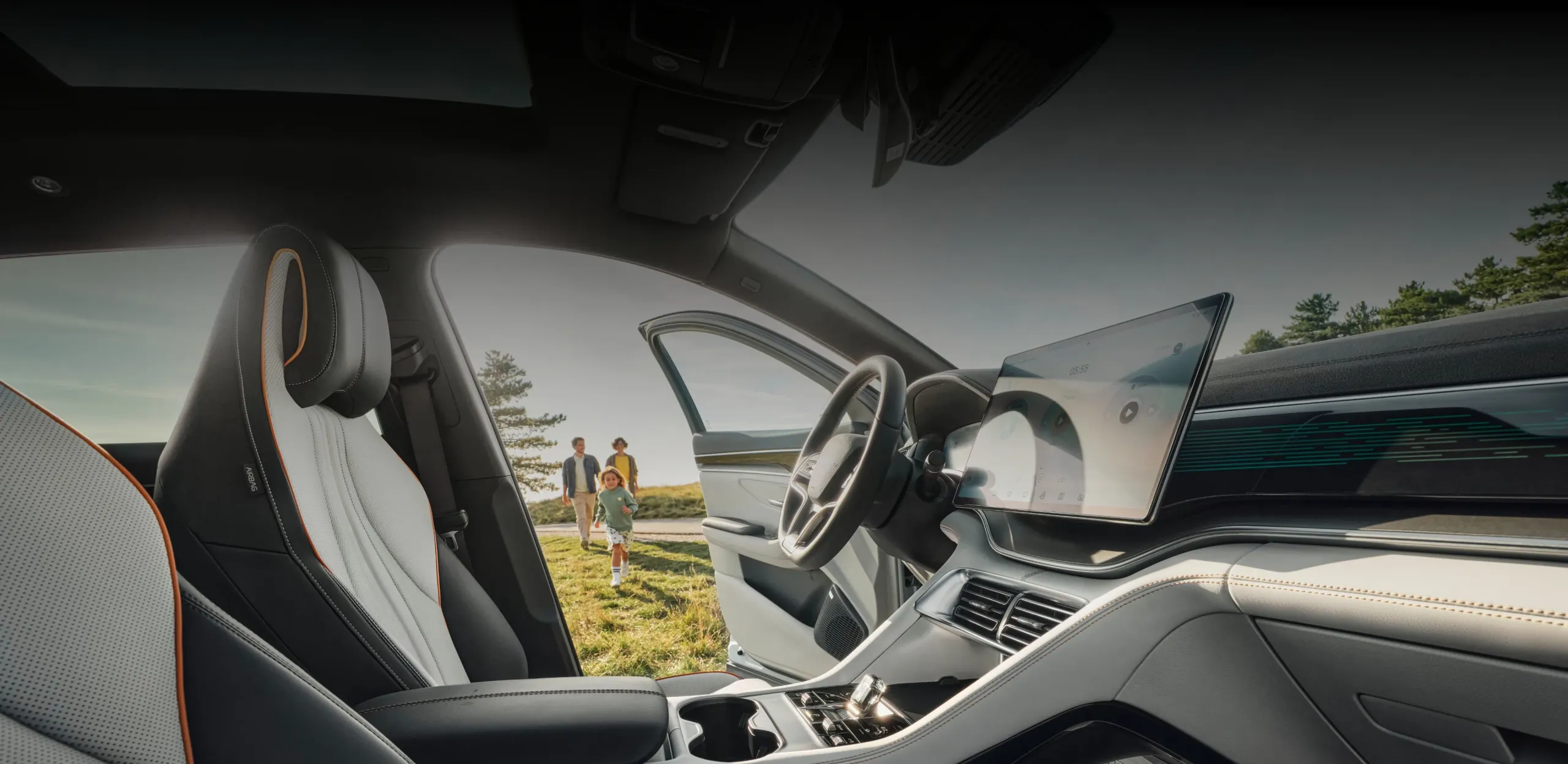 Vista a partir do interior do BYD SEAL U de uma família que se dirige para o carro