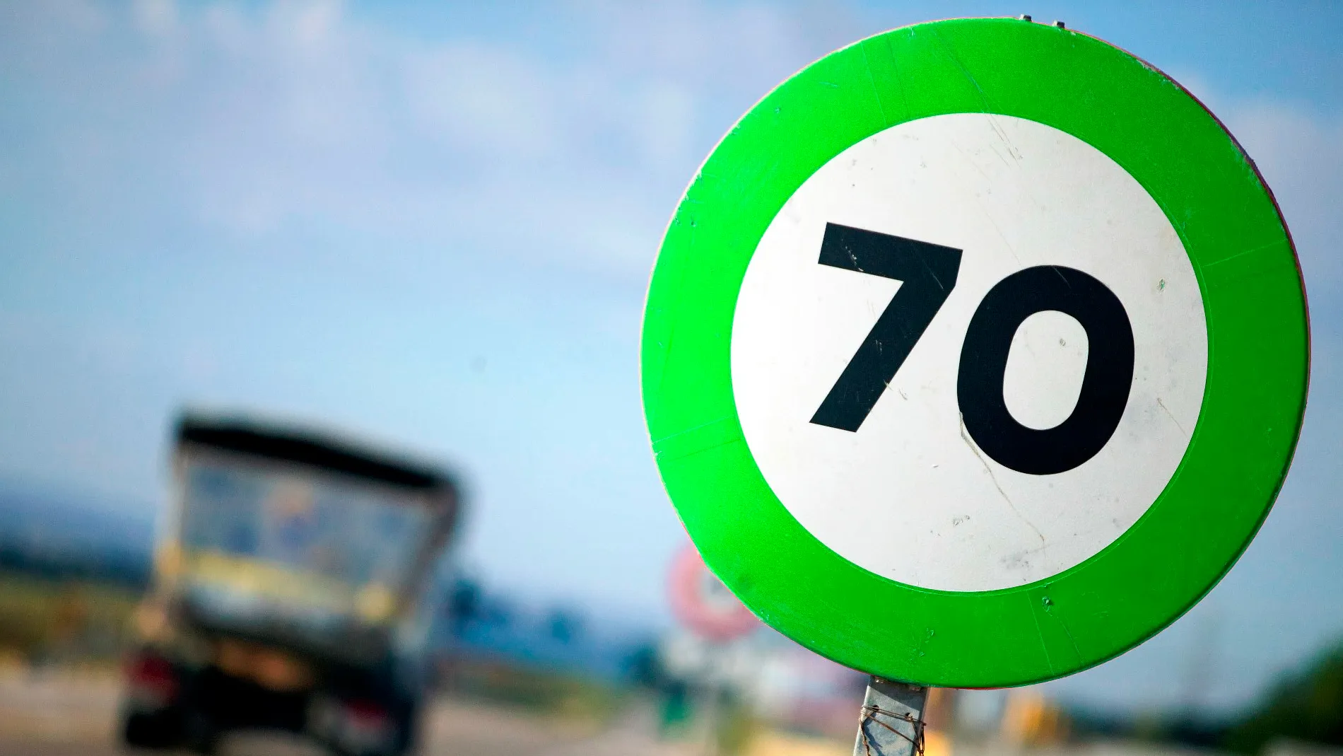 Señal de tráfico verde mostrando 70 km/h cómo límite de velocidad en la vía. Nueva señal de tráfico verde indicando límite de 70 km/h en carretera.