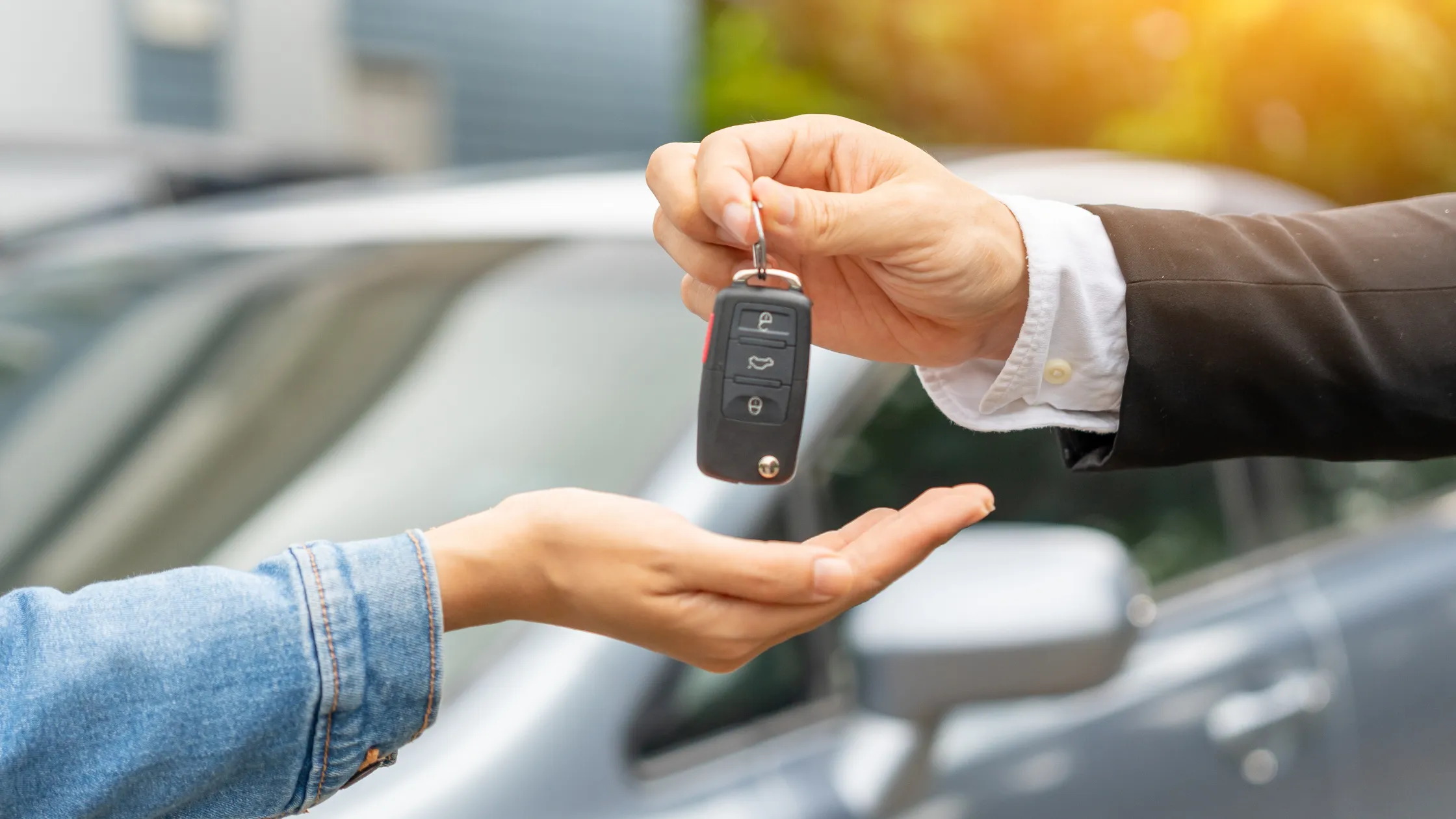 Entrega de llaves de vehículo. Llaves de coche pasando de mano al vender un coche financiado.