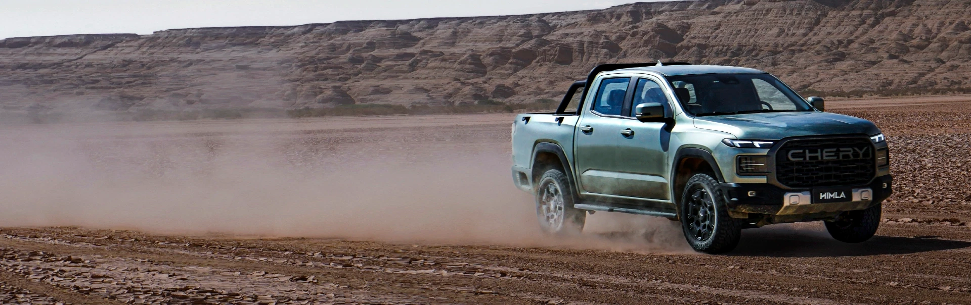 Pick-up Chery em condução fora da estrada que está a levantar poeira num cenário desértico com montanhas ao fundo