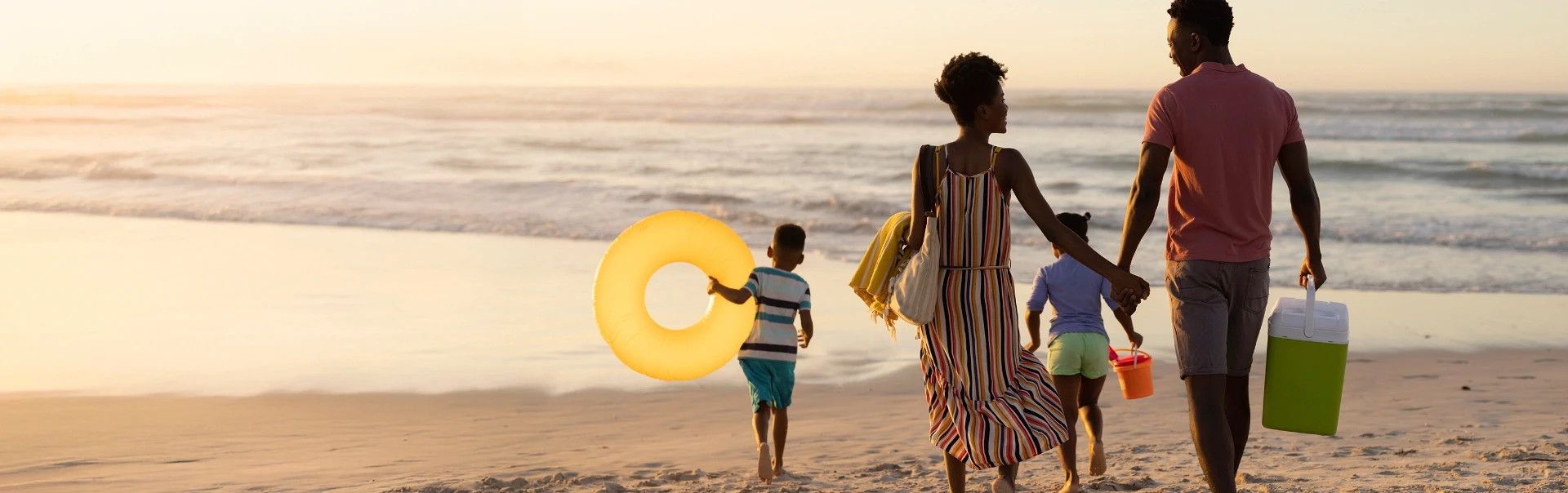 Happy family enjoying a sunset stroll on the beach, creating lasting memories with their children