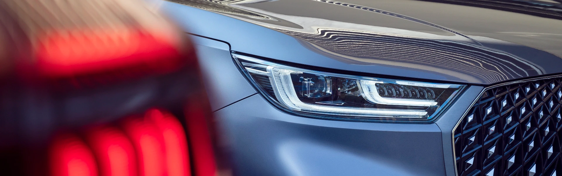 Prestigious front view of the luxurious grey Chery 8 featuring its signature diamond-patterned chrome grille and advanced LED headlights in a refined park setting