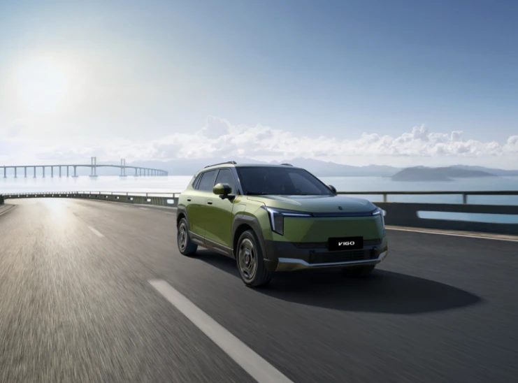 Dongfeng VIGO verde a circular numa estrada junto ao mar.