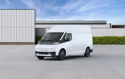 Carrinha comercial branca Farizon SV com tejadilho alto, estacionada num pátio exterior em frente a um edifício de linhas modernas com céu limpo ao fundo. 