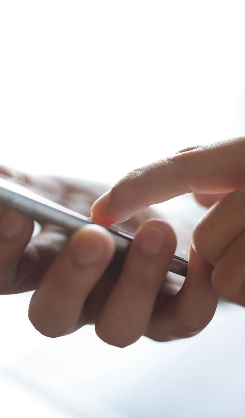 mão a segurar num smartphone e outra mão a interagir com o ecrã