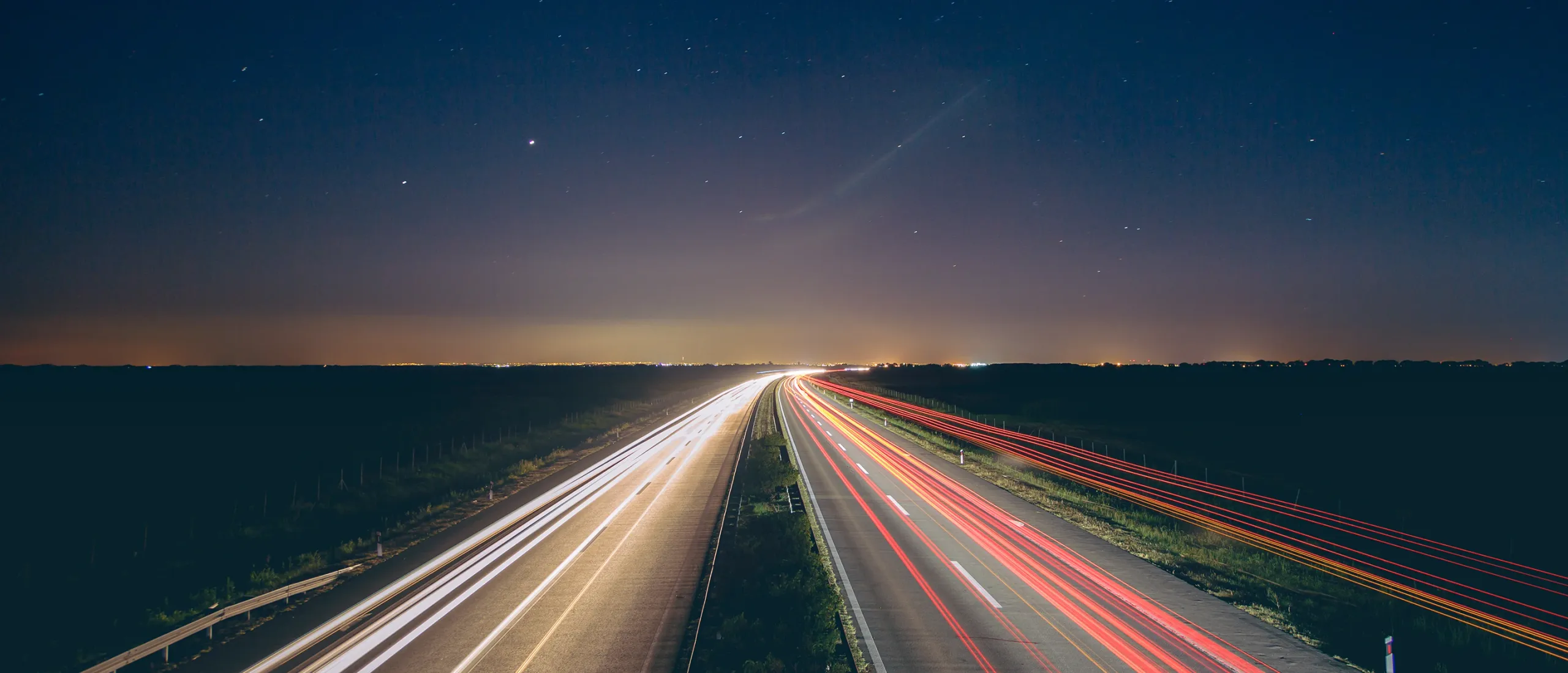 fotografia noturna de uma auto-estrada com feixes de luzes variadas