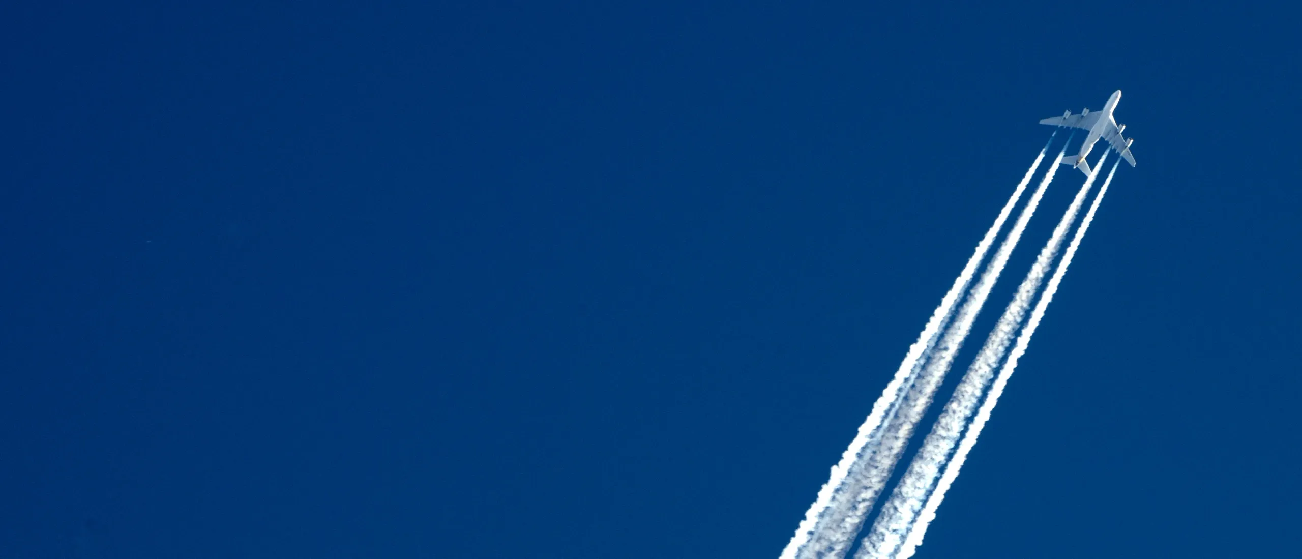 avião comercial a voar com rasto de fumo branco