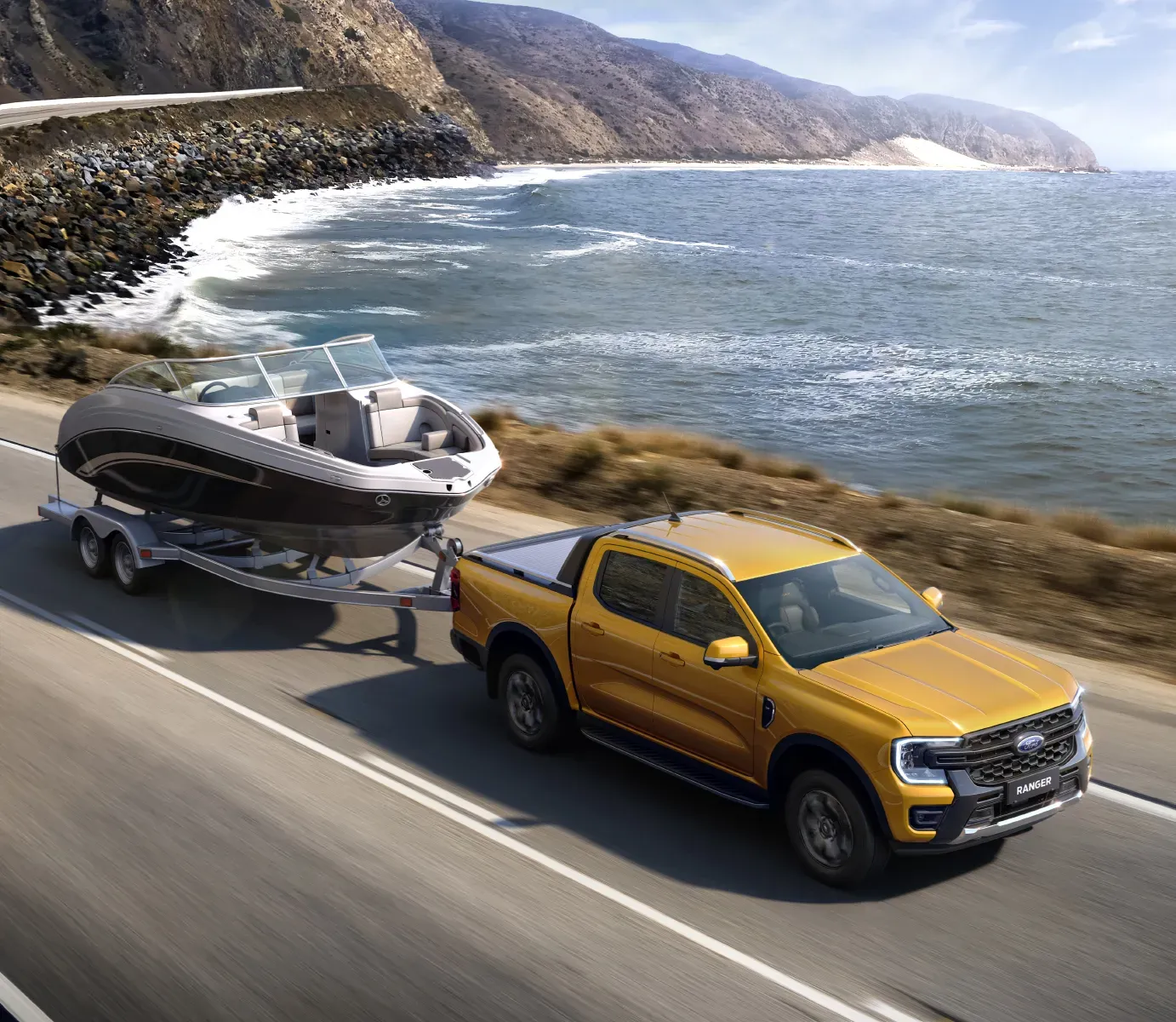 Ford Ranger towing a boat on a road by the sea