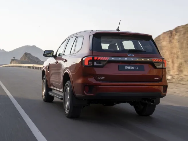 Ford Everest driving along a road at sunset