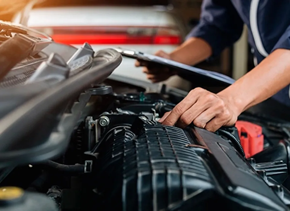 Mécanicien vérifiant le moteur d'une voiture 