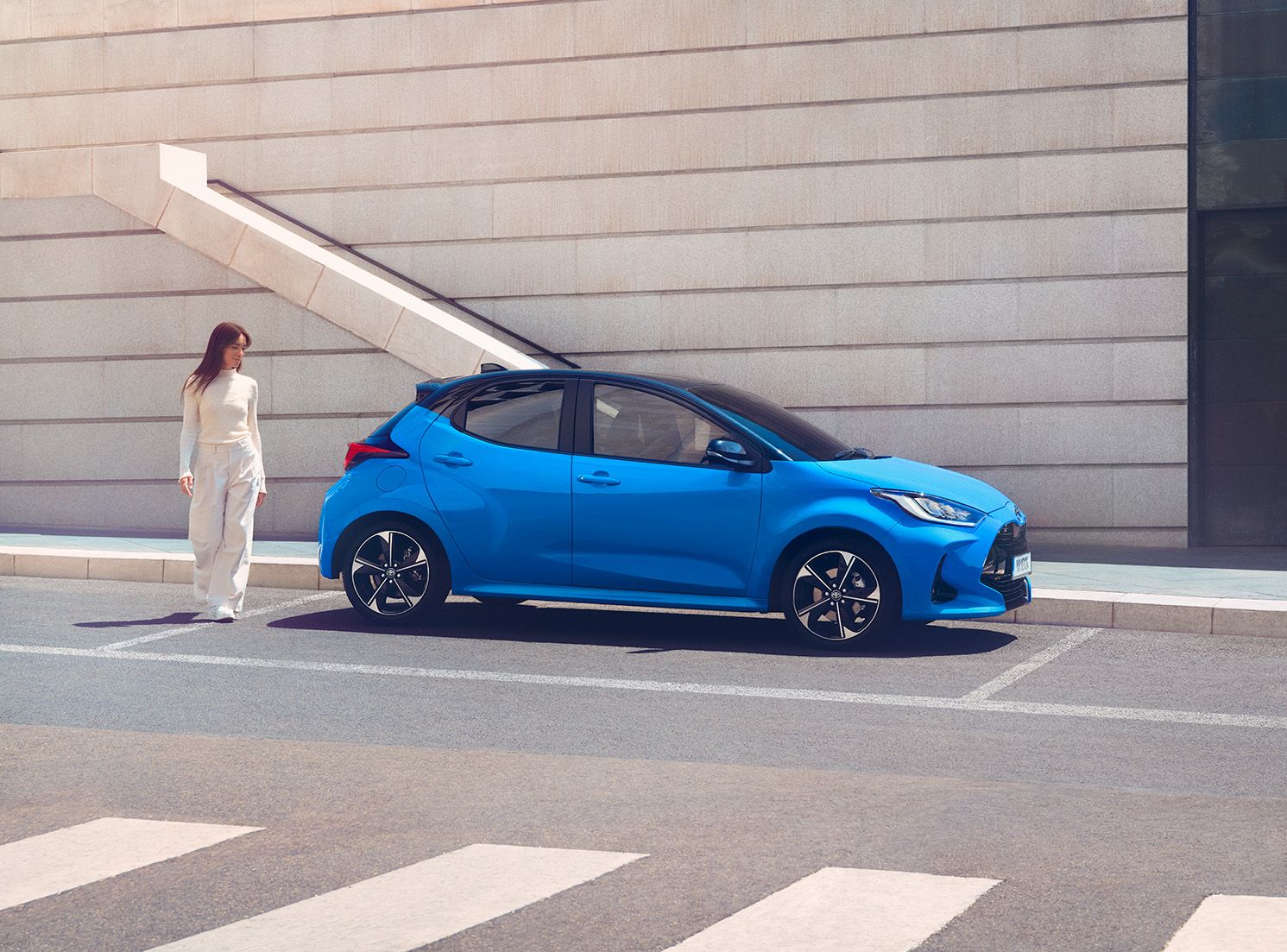 Toyota Yaris azul estacionado com vista lateral